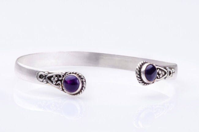 Un bracelet en argent orné de pierres violettes, élégant et raffiné sur fond blanc