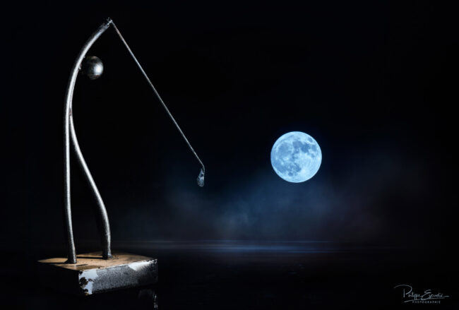 Statuette en fer d'un homme jouant au golf avec une pleine lune en arrière plan