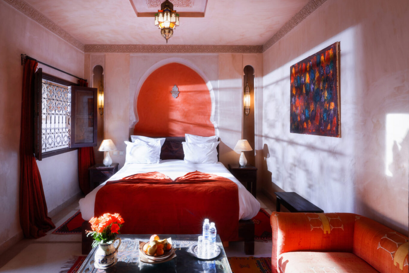 chambre de riad avec un lit et une fenêtre par laquelle perce un rayon de soleil