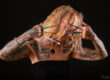Photo artistique en studio d’une femme tatouée avec des pinceaux devant le visage – portrait par photographe à Carcassonne