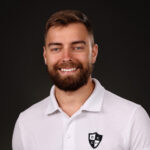 portrait de face d'un jeune homme barbu souriant