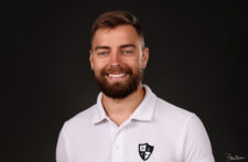 portrait de face d'un jeune homme barbu souriant