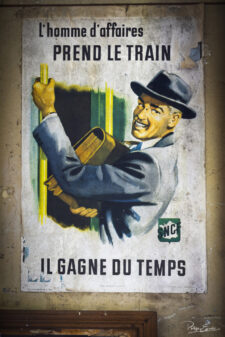 Vieille affiche SNCF montrant un homme d’affaires montant dans un train.