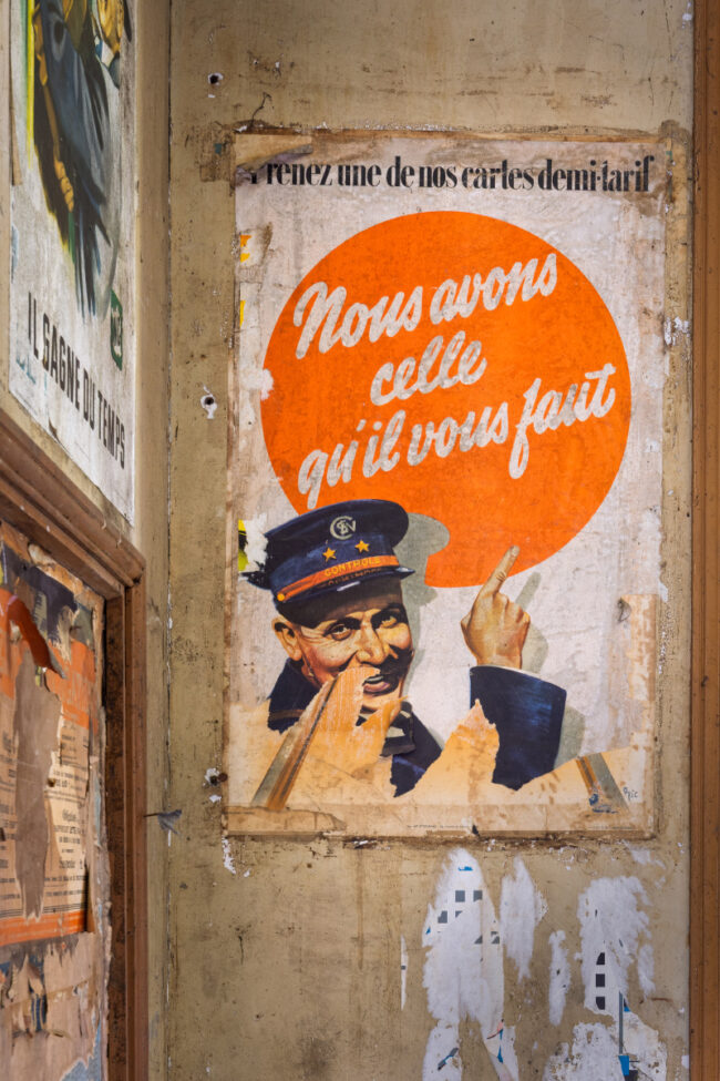 Vieille affiche SNCF demi-tarif avec contrôleur pointant un texte orange