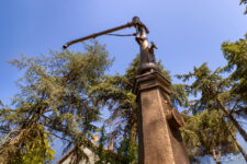 Ancienne pompe à eau de gare en métal sous un ciel bleu