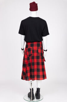Vue de dos d’un mannequin en studio portant une jupe homme à carreaux rouges et noirs avec poches, style alternatif masculin