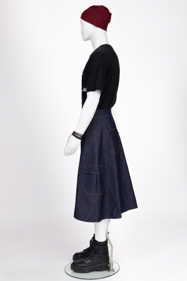 Vanessa, la fille qui glisse ses mains sous les Jupes des Hommes 12 Vue de profil d’un mannequin en studio portant une jupe homme en jean brut avec poches cargo, collection La Jupe qui fait mâle.