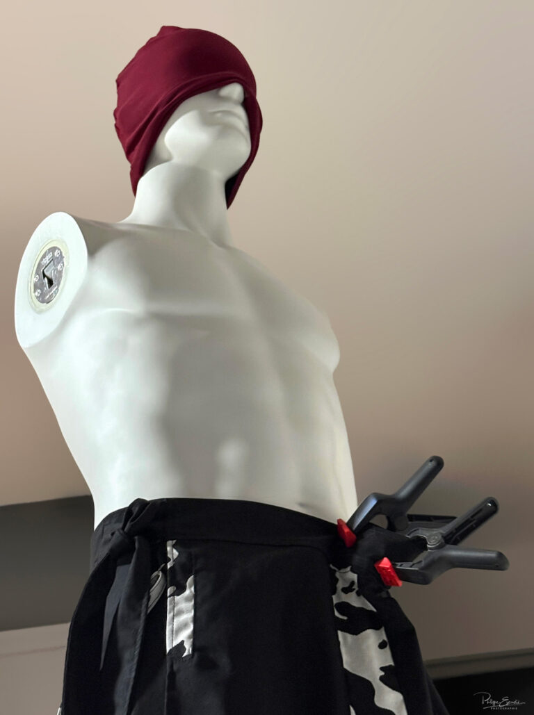 Vanessa, la fille qui glisse ses mains sous les Jupes des Hommes 2 Un mannequin sans bras avec un bandeau sur la tête et des pinces pour tenir le haut d'une jupe
