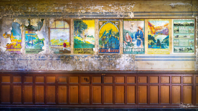 Mur d’une salle d’attente de gare décoré d’anciennes affiches ferroviaires