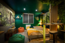 Chambre décorée sur le thème jungle avec lit double, ambiance végétale immersive et un vidéoprojecteur qui diffuse sur le mur un film de jungle