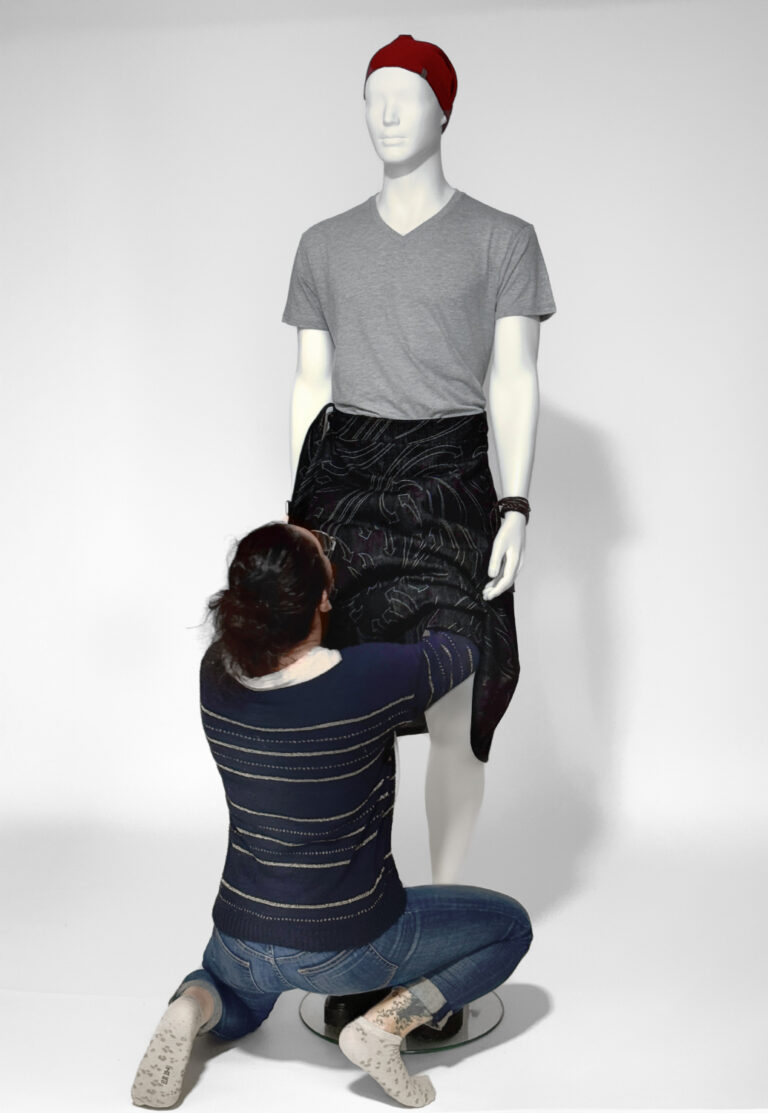 Vanessa, la fille qui glisse ses mains sous les Jupes des Hommes 1 Vanessa de l’atelier couture I Fil Good en préparation d’un mannequin portant une jupe homme, prise de vue studio pour la collection La Jupe qui fait mâle.