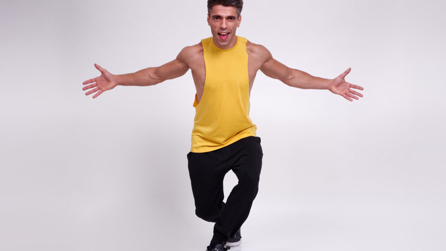 Portrait en studio capturant un geste ouvert et accueillant dans une posture énergique.