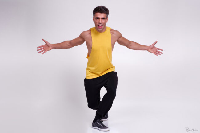 Portrait en studio capturant un geste ouvert et accueillant dans une posture énergique.