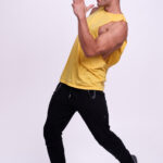 Portrait d’un homme en mouvement lors d’une séance photo en studio, avec une pose expressive et sportive.