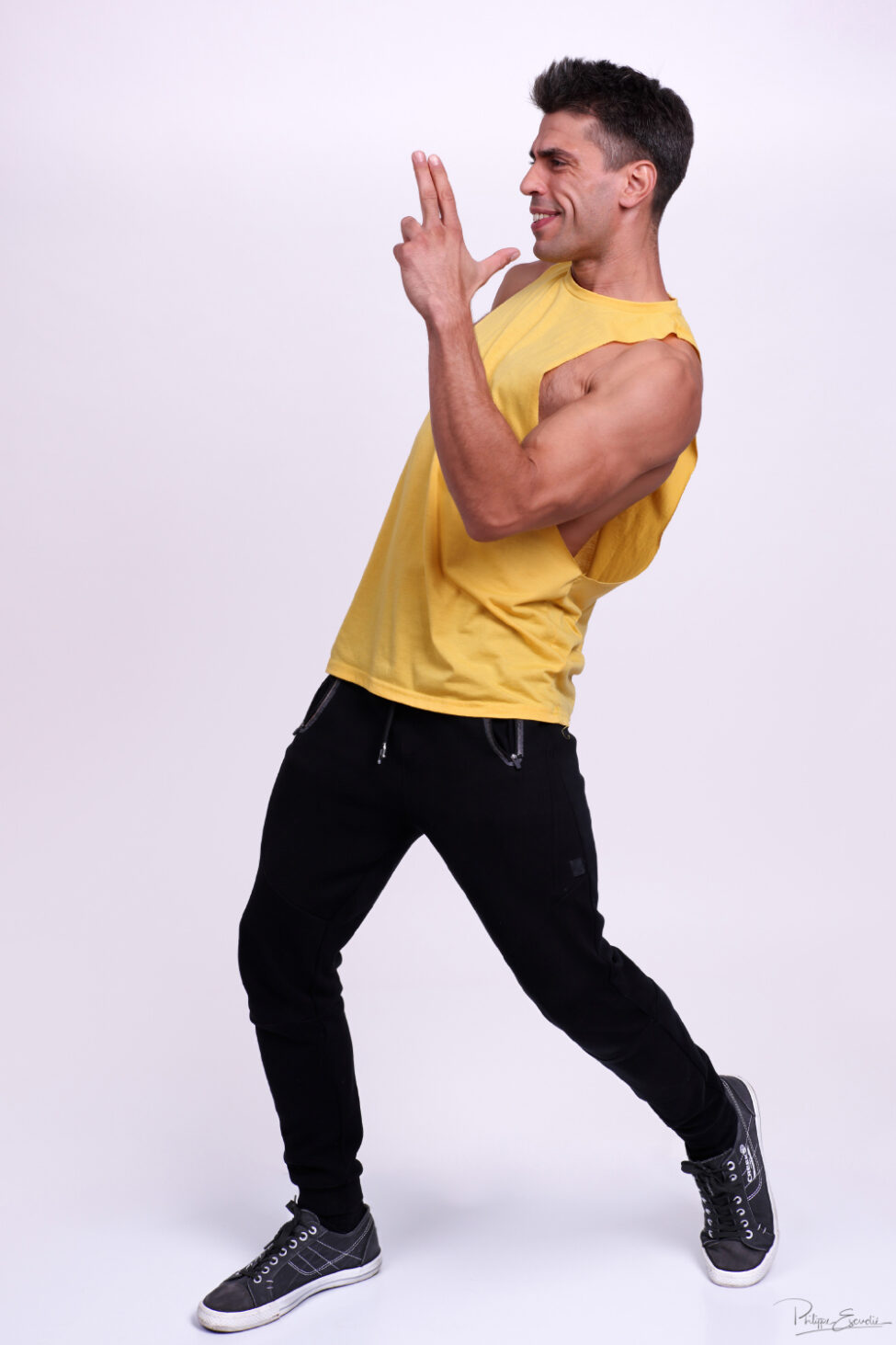 Portrait d’un homme en mouvement lors d’une séance photo en studio, avec une pose expressive et sportive.