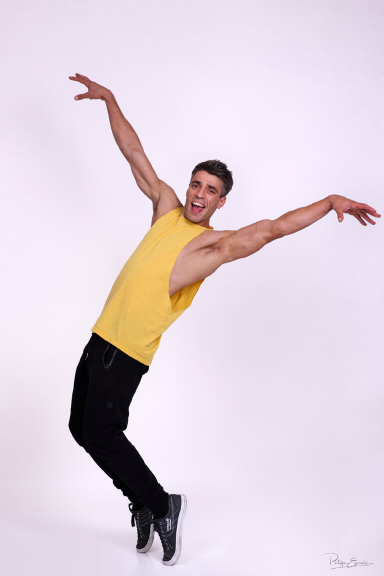 Portrait d’un homme en mouvement lors d’une séance photo en studio, avec une pose expressive et sportive.