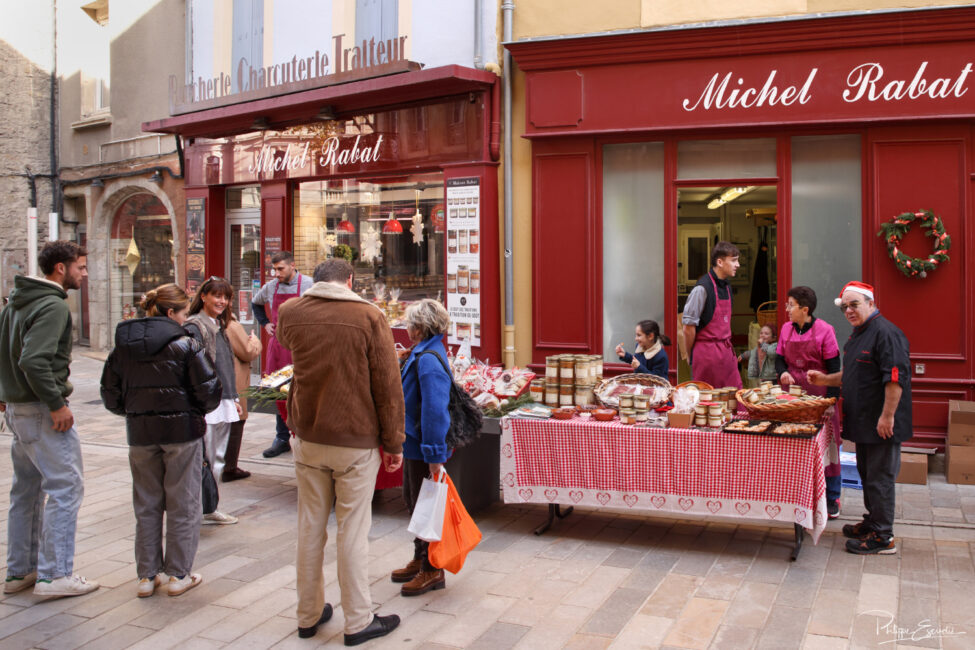 Animation commerciale devant une boutique, avec stand extérieur, produits exposés et passants dans la rue.