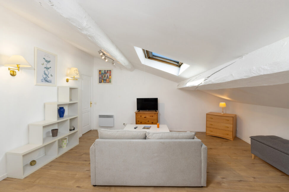 Salon lumineux sous toiture avec fenêtres de toit et mobilier contemporain