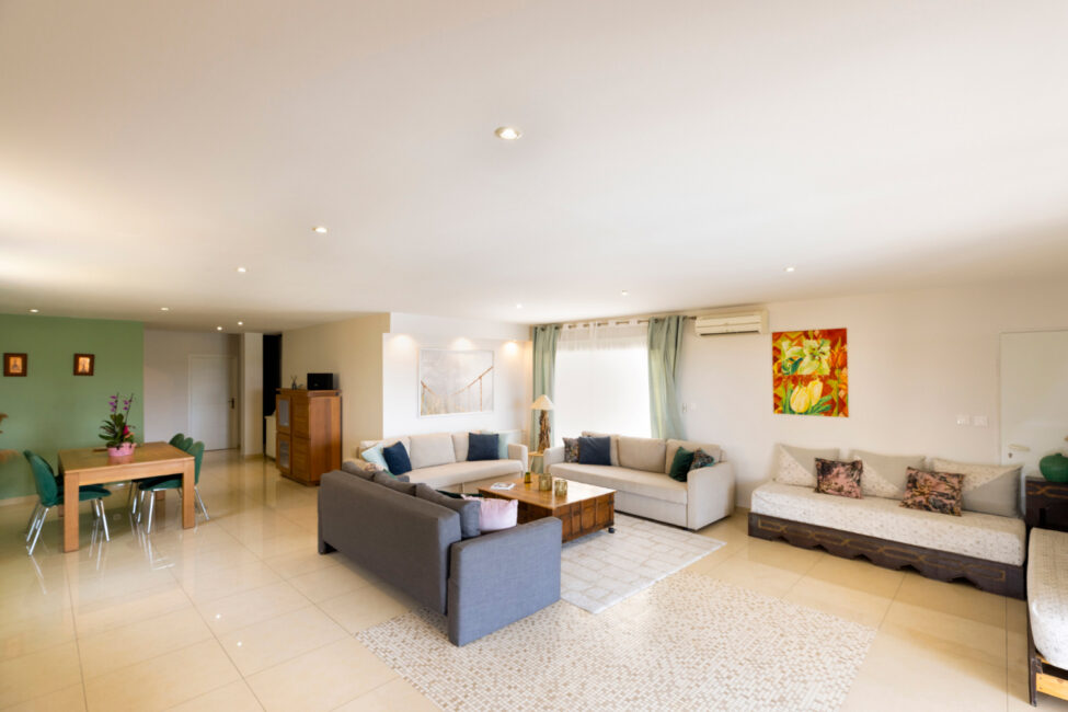 Photographe immobilier à Carcassonne : quand un shooting professionnel change tout 8 Grand salon avec espace repas, canapés et larges ouvertures.