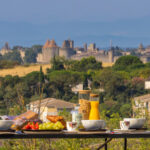 able dressée pour le petit-déjeuner avec la Cité de Carcassonne en arrière-plan.
