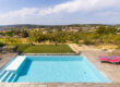 Piscine contemporaine avec terrasse et vue dégagée sur les collines environnantes.