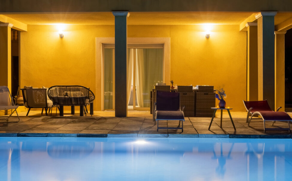 Photographe immobilier à Carcassonne : quand un shooting professionnel change tout 13 Terrasse couverte et piscine éclairées en soirée.