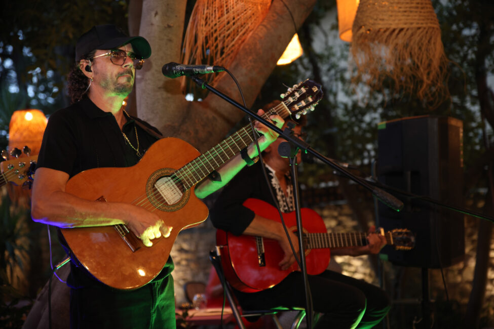 Les Noy’s et le Coco Bongo au cœur de la Féria de Carcassonne 15 Gros plan de Jéricho du groupe les Noy's, une guitare à la main et une casquette sur la tête, en concert plein air.